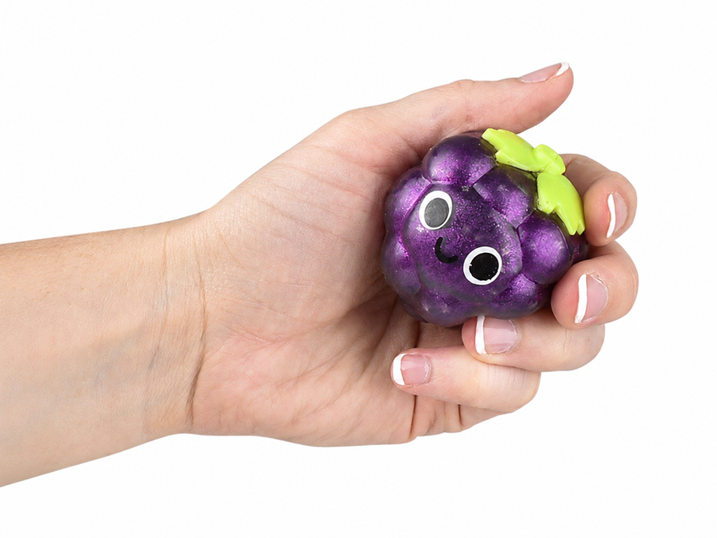 Hand holding a purple glitter grape squishy toy with green leaves and cartoon face